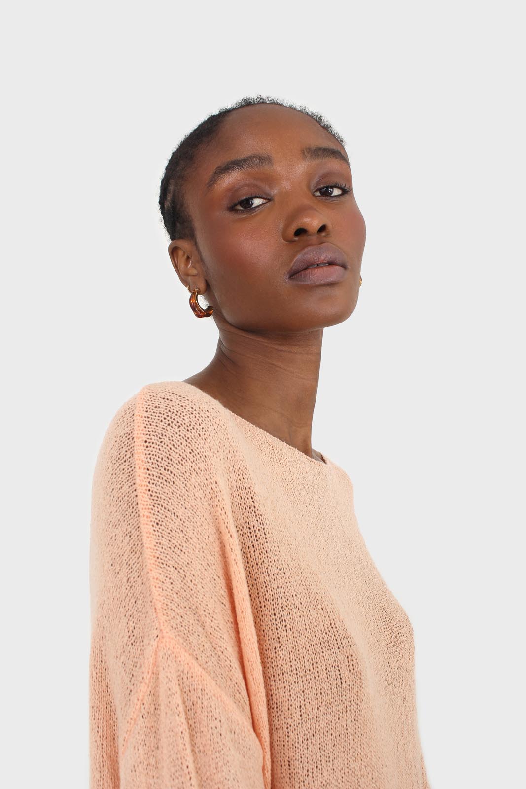 Pale orange wide neck long sleeved loose knit top