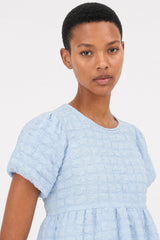 Light blue textured puff short sleeve tiered blouse